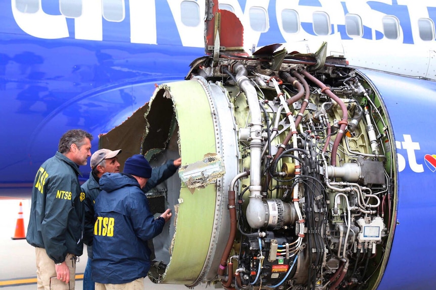 Investigators inspect a damaged Southwest Airlines plane engine.