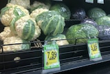 A supermarket shelf displaying cauliflowers marked with a $7.99-per-unit pricetag.