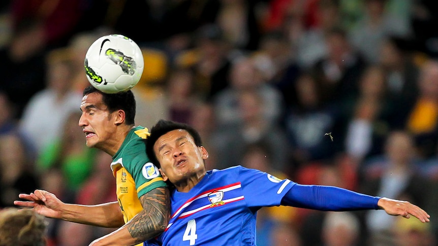Tight battle ... Thailand's Chonlatit Jantakam (right) and Tim Cahill (left) leap for possession.
