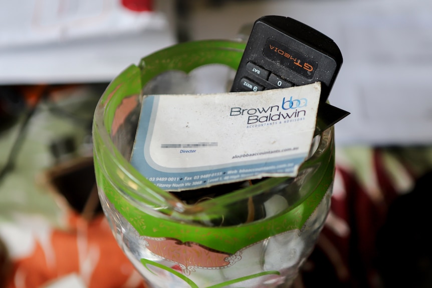 A business card sitting in a glass cup