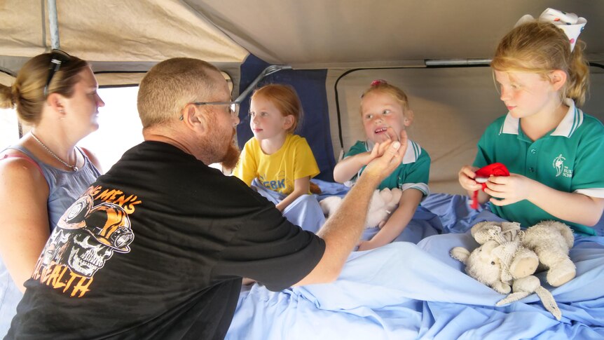 A family squeezed into a camper van.