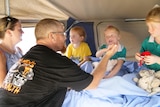A family squeezed into a camper van.