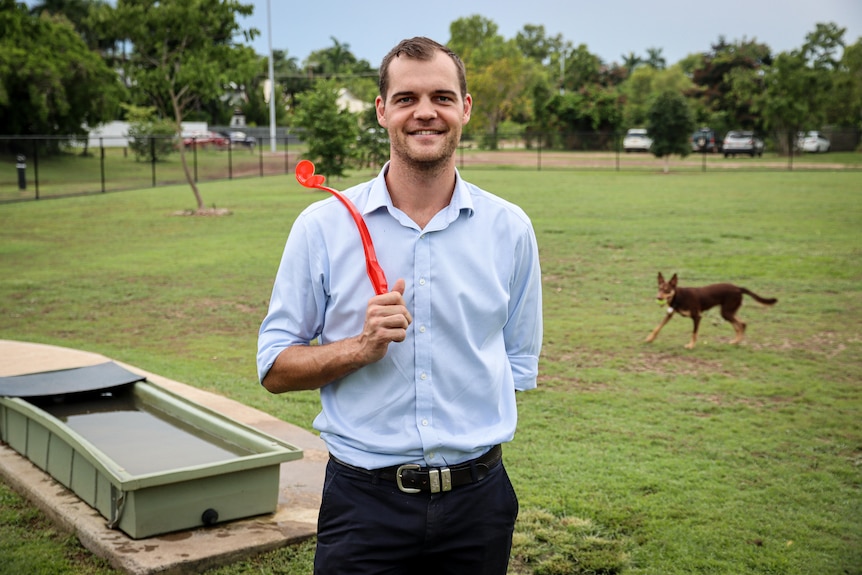 A man and his dog at a dog park.