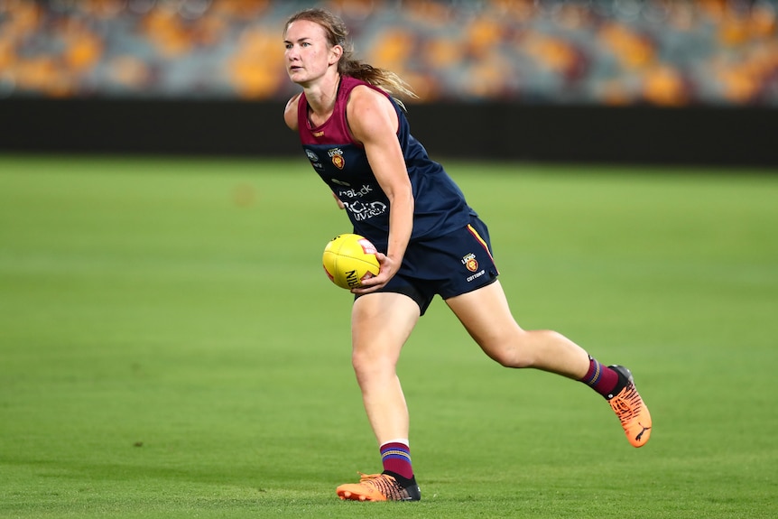 Shannon Campbell handballs during an AFLW match.