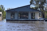 A house just sitting barely above the flood waters 