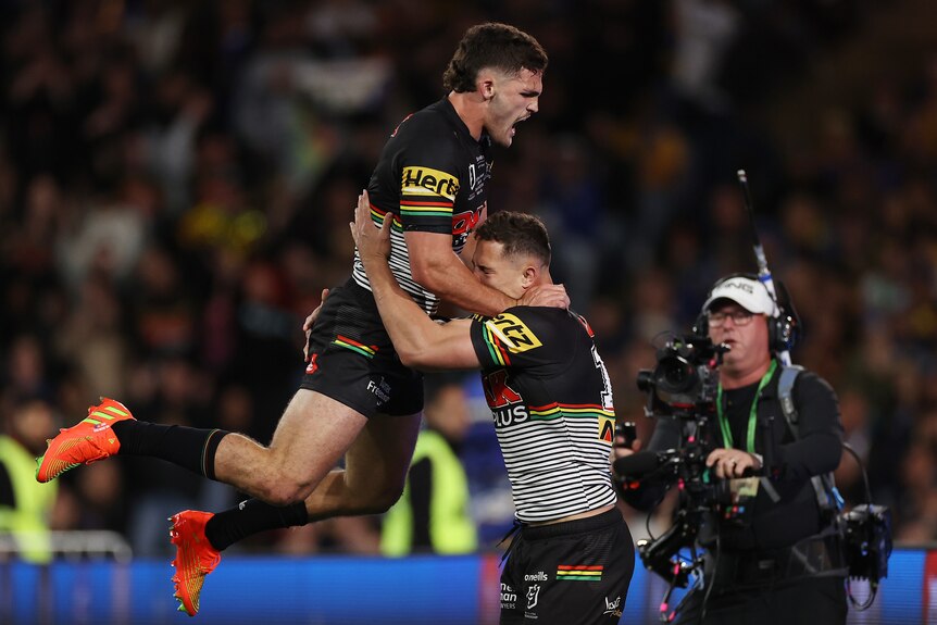 Nathan Cleary leaps into Scott Sorensen in celebration of a try