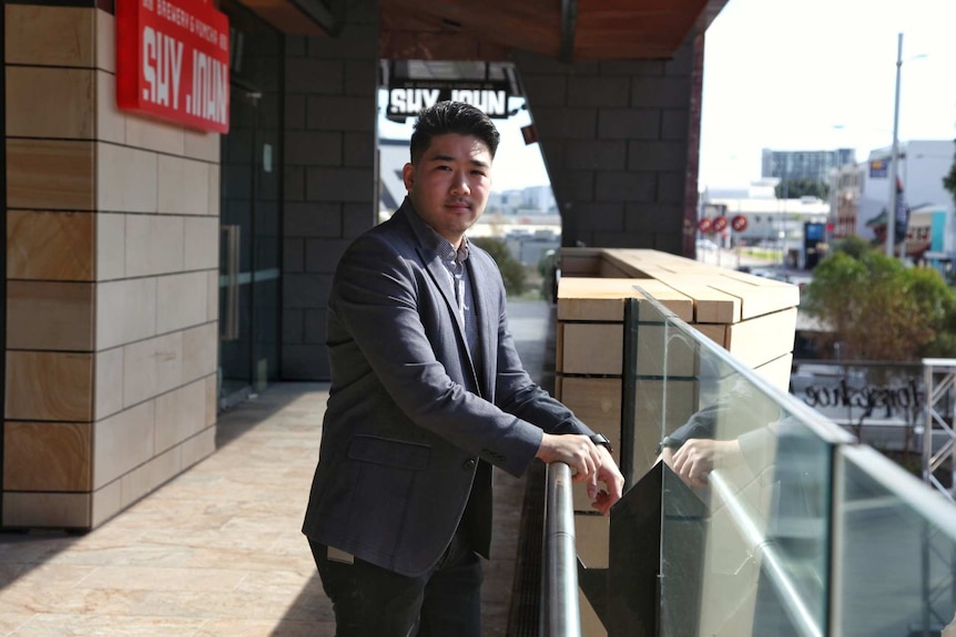 Justin Lim stands on a balcony.