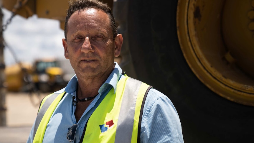 A mid shot of Joe Tropiano from Stone Civil standing outdoors wearing a hi-vis vest and blue shirt.