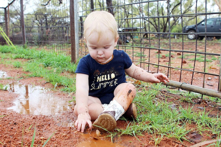 Toddler Toby Campbell plays in a muddy puddle after rain at drought-ravaged Rosebud Station, between Cloncurry and Mount Isa.