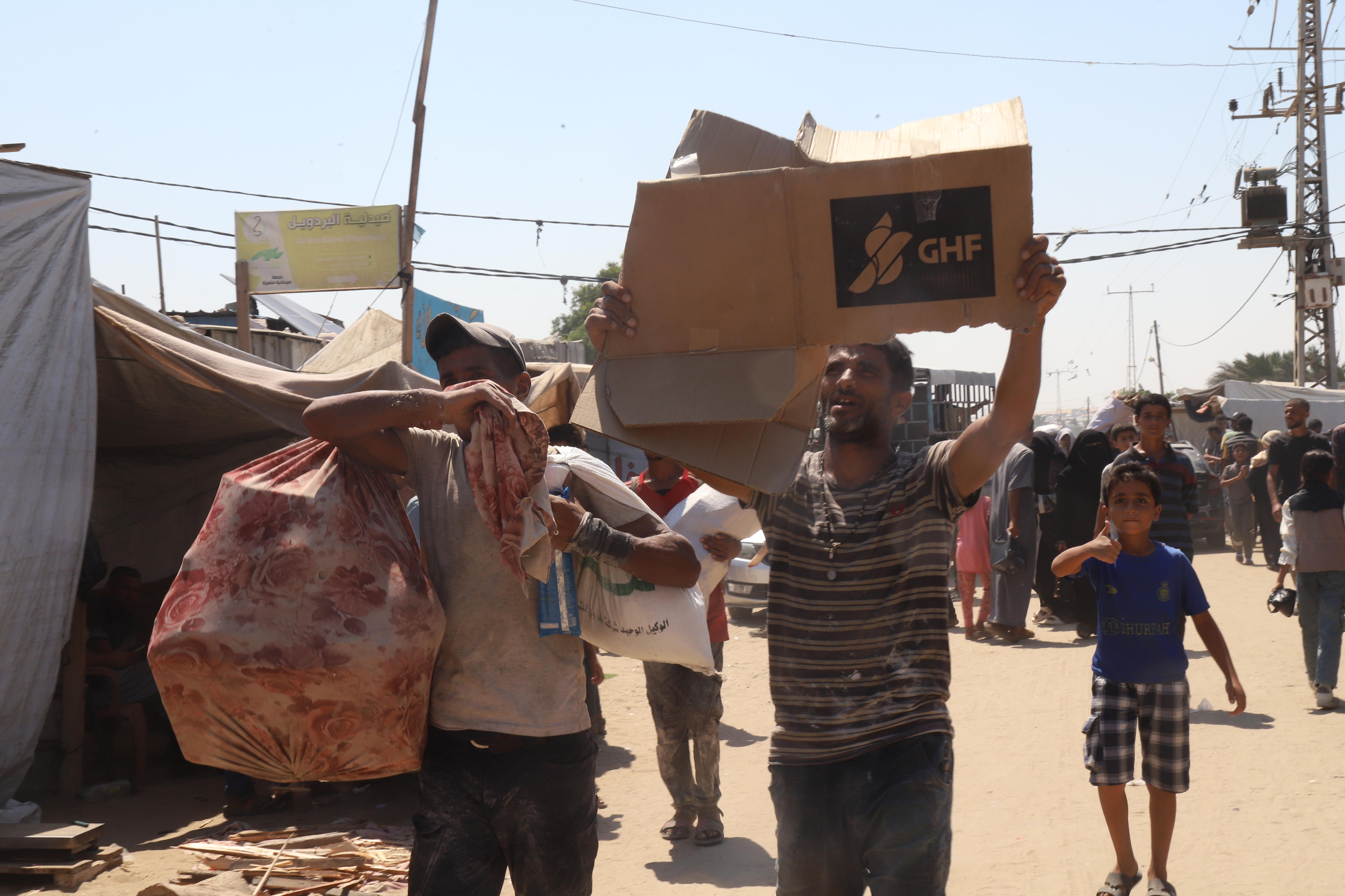 Abu Khaled holds a broken down GHF cardboard box aloft.