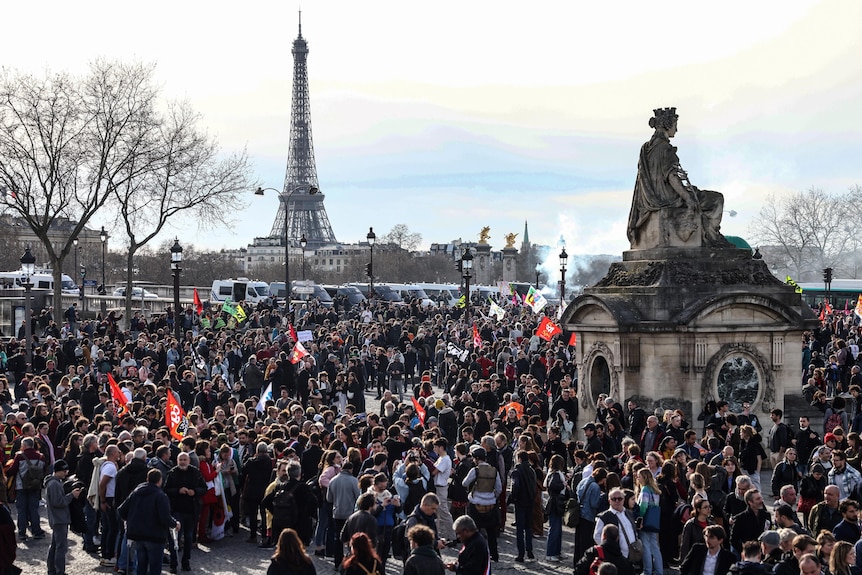 A large group of people is pictured protesting on Place de la Concorde, in the background the Eiffel tower.