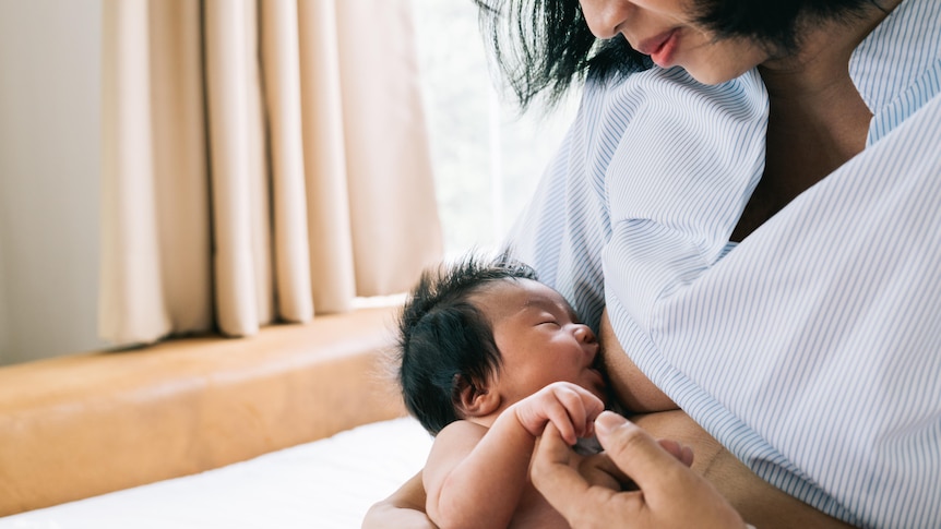 woman breastfeeds her newborn baby