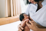 woman breastfeeds her newborn baby