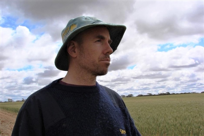 A man in a hat looking at a filed