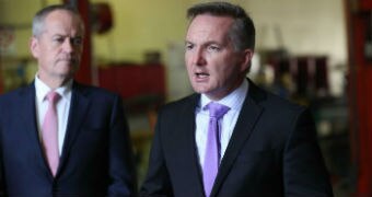 Two men in suits stand together as they speak to media