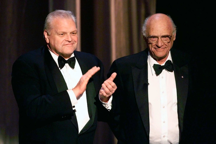 Brian Dennehy and Arthur Miller stand together wearing tuxedos.
