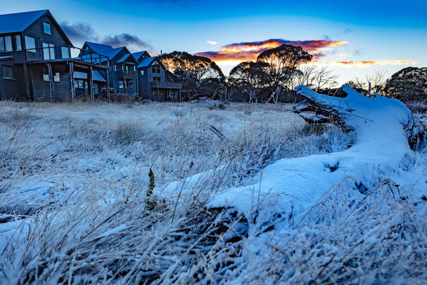 A photo of the small Victorian alpine town of Dniner Plain near Mount Hotham at dawn with a dusting on snow.