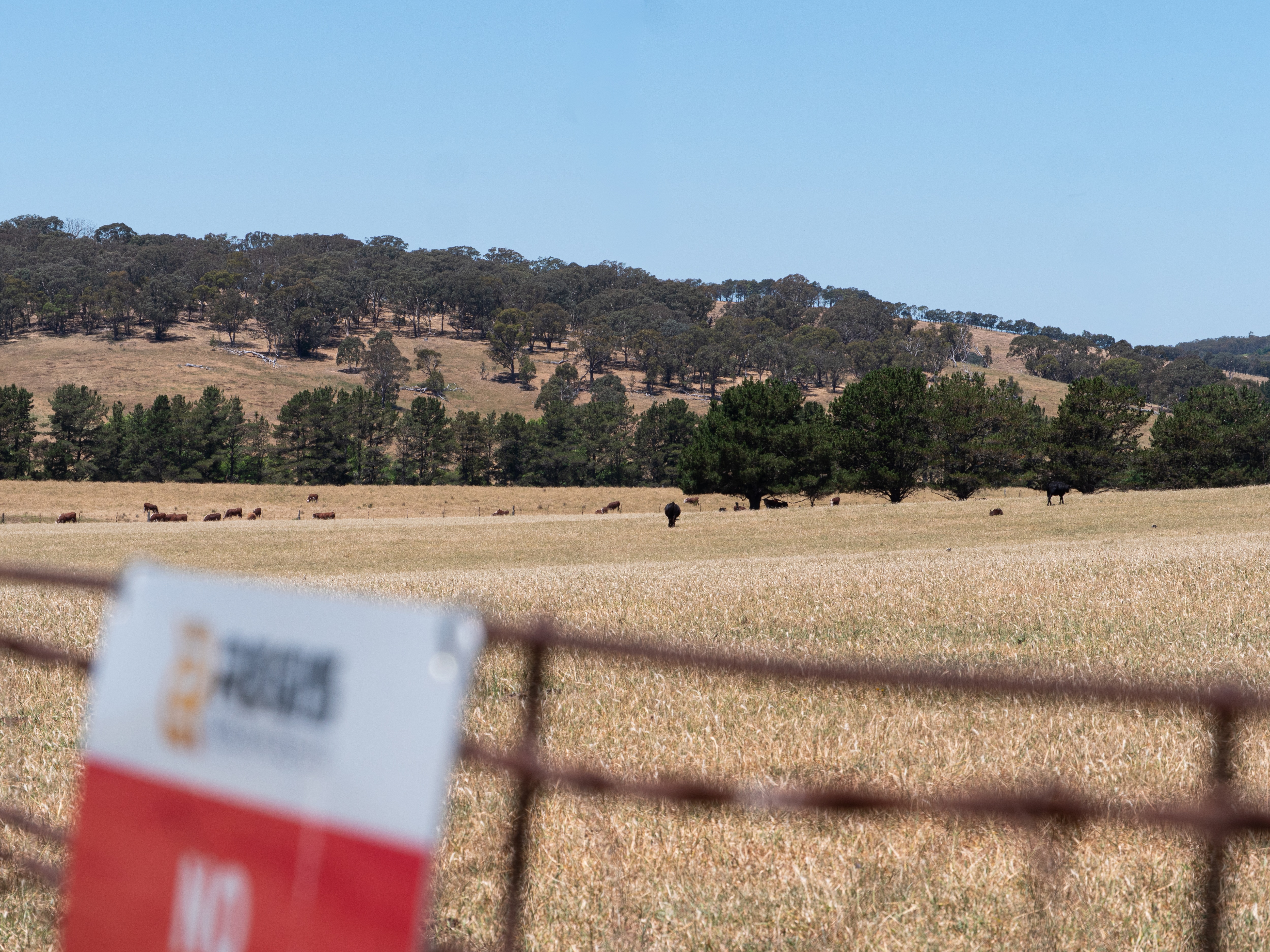 Tierras de cultivo con potreros, carteles y vallas.