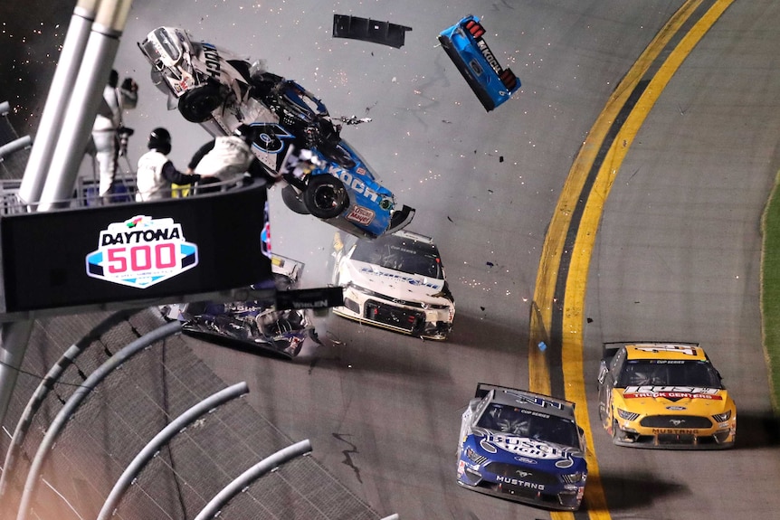 A car breaks into pieces as it is airborne after a crash near the finish line at the Daytona 500.