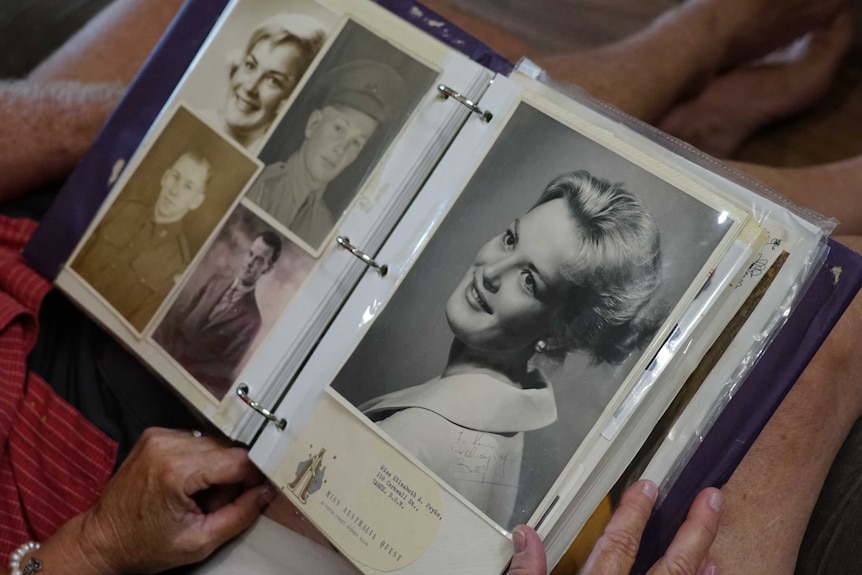 Black and white photos of Liz Holmes can be seen on the lap of her daughter Sharon.