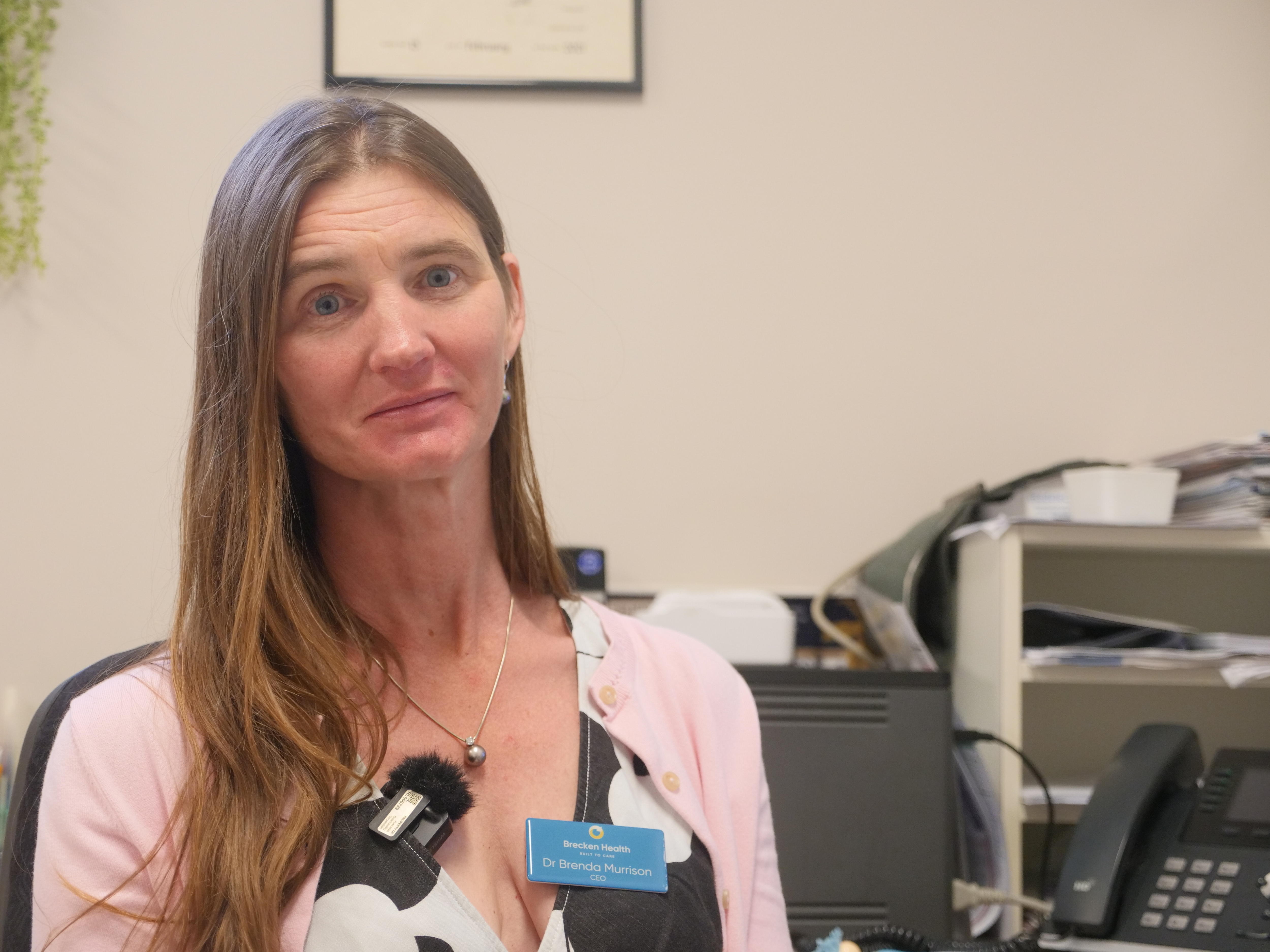 Head and shoulders pic of a woman with long auburn hair