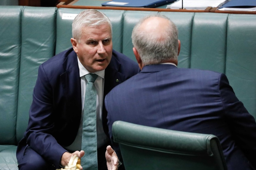 Michael McCormack leans in and speaks with Prime Minister Scott Morrison in the House of Representatives chamber