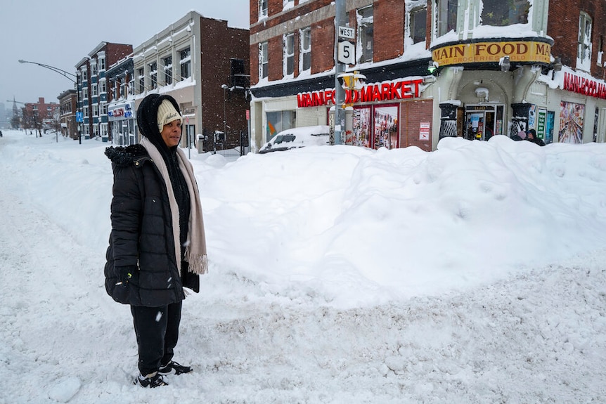 A woman stands on a street in NY after a massive snow storm blanketed the city.