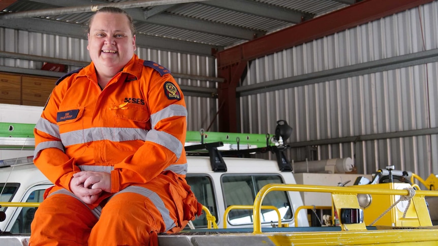 Tanya Wittmann, wearing her orange SES uniform, sits atop a rescue boat