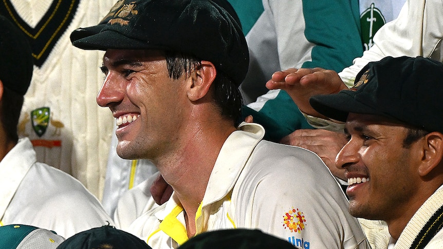 A group of Australian cricketers chat and laugh in the middle of a photo session after their win in the Ashes series.