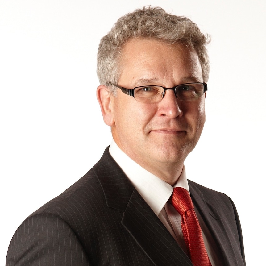 Man in glasses and necktie looks at camera