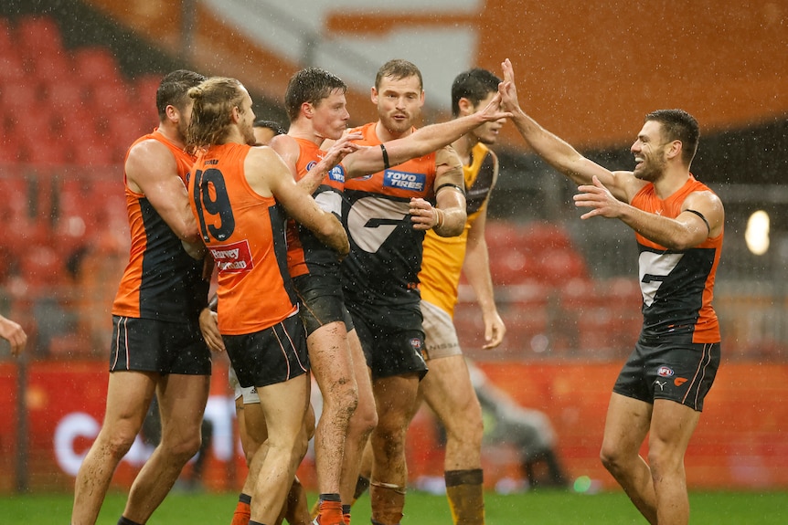 A bunch of GWS players surround Jacov Wehr to congratulate him