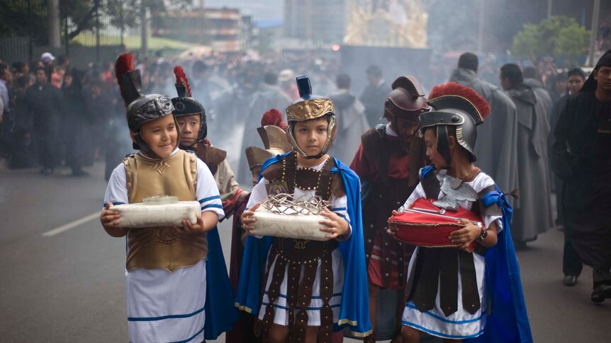 Children dressed as Romans take part in a Good Friday procession