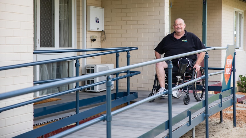 Mr Fairbairn on the wheelchair ramp outside his home.