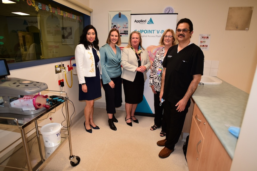 A group of doctors and medical service directors stand in a laboratory