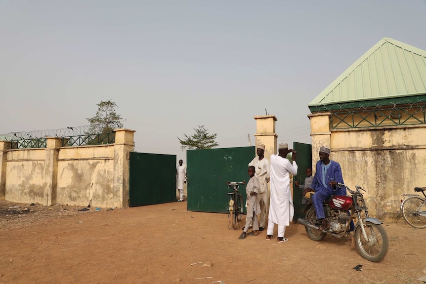 Parents of kidnapped students wait outside the school for information