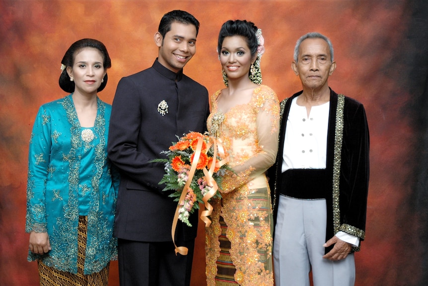 A photo of a bride and groom with the husband's parents either side.