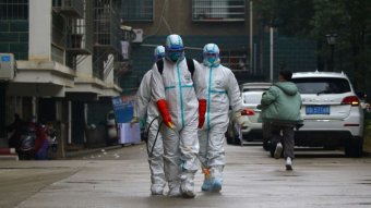 Workers from disease control and prevention department in protective suits disinfect a residential area in China.