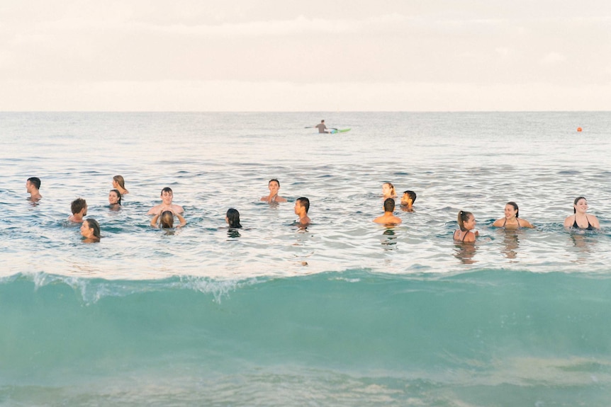 A group of young people swimming in the ocean.