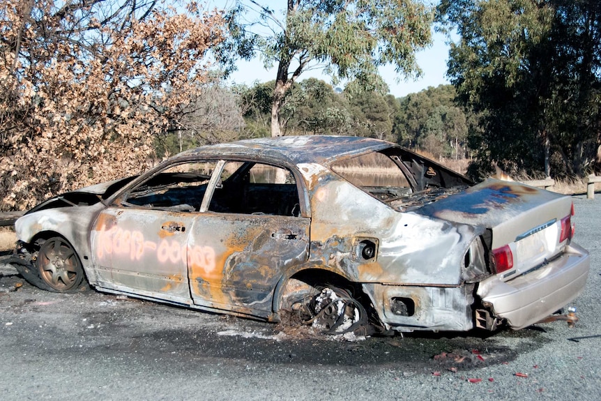 Burnt-out car beside Lake Burley Griffin