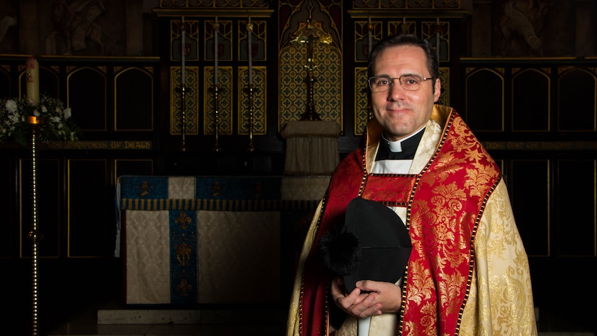 Anglican rector Daniel Dries standing in front of the altar at Christ Church St Laurence.