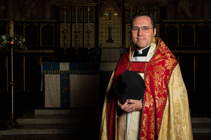 Anglican rector Daniel Dries standing in front of the altar at Christ Church St Laurence.