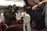 A composite image of an armed police officer and a bound man, both on a Malaysia Airlines flight.