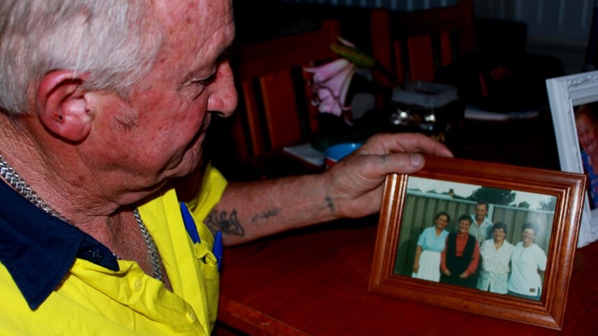 Wayne Howarth holds a photo of him and his siblings, including his sister who has died.