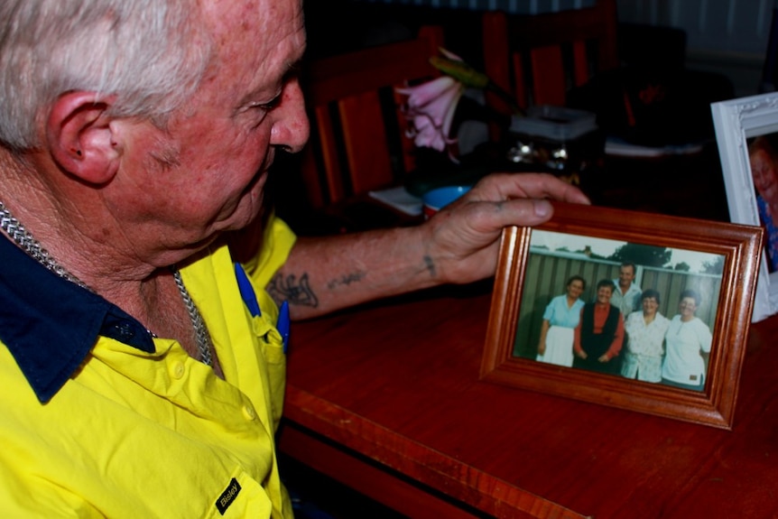 Wayne Howarth holds a photo of him and his siblings, including his sister who has died.