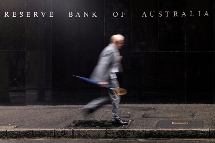 Pedestrian walks past Reserve Bank building in Sydney