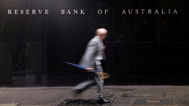 Pedestrian walks past Reserve Bank building in Sydney
