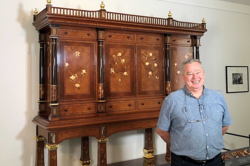 Master craftsman Geoff Hannah stands in front of his final large work, the Hannah Cabinet
