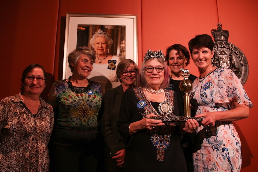 Women stand on stage at the 2017 Ernie Awards holding the Gold Ernie award
