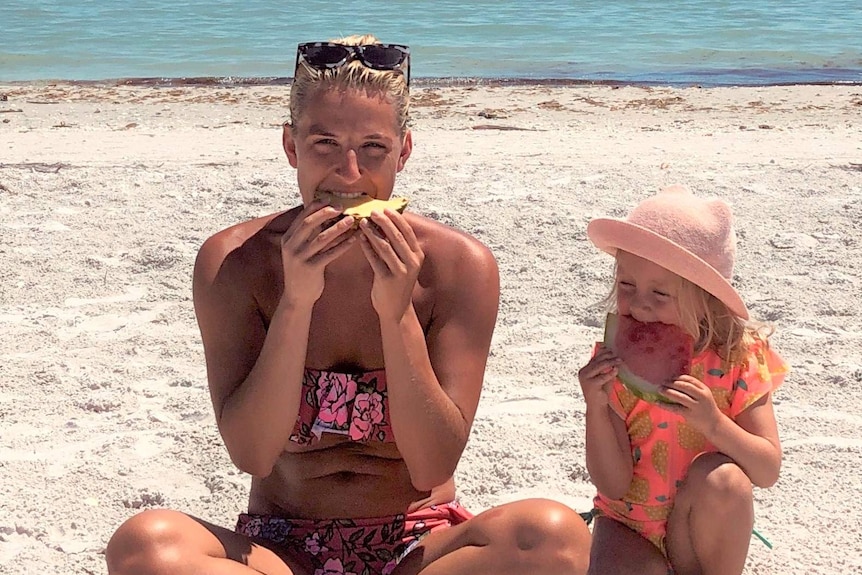 Anna Araszkiewicz with her daughter on a beach