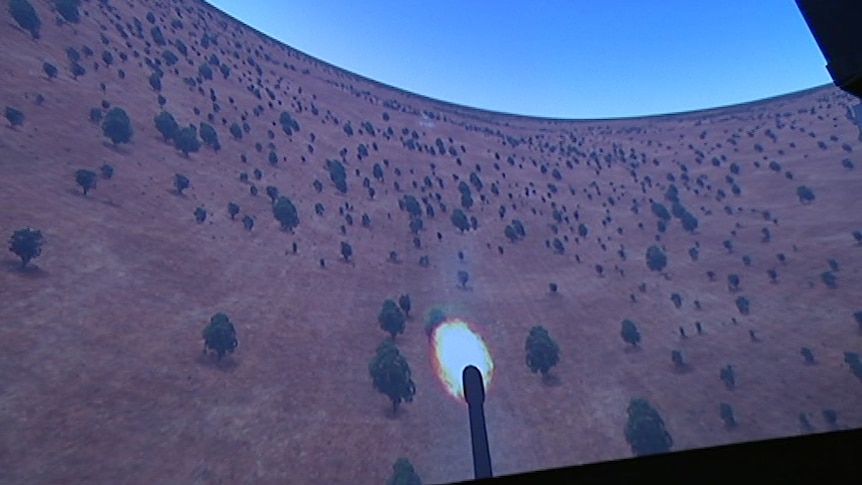 A video screen showing an animation with a missile firing from a plane down to a target on land